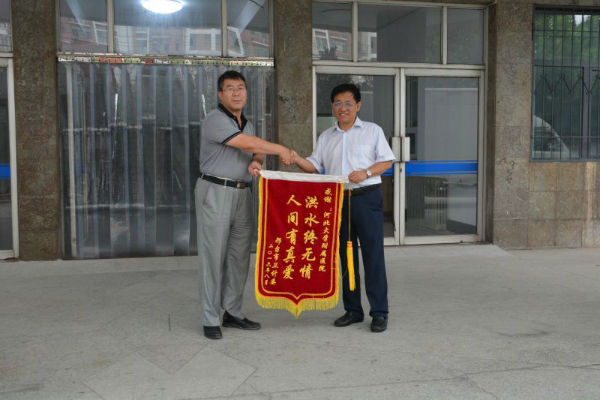邢台市卫计委副主任李建东亲手将写有“洪水终无情,人间有真爱”的锦旗赠予附属医院张海松院长表示感谢